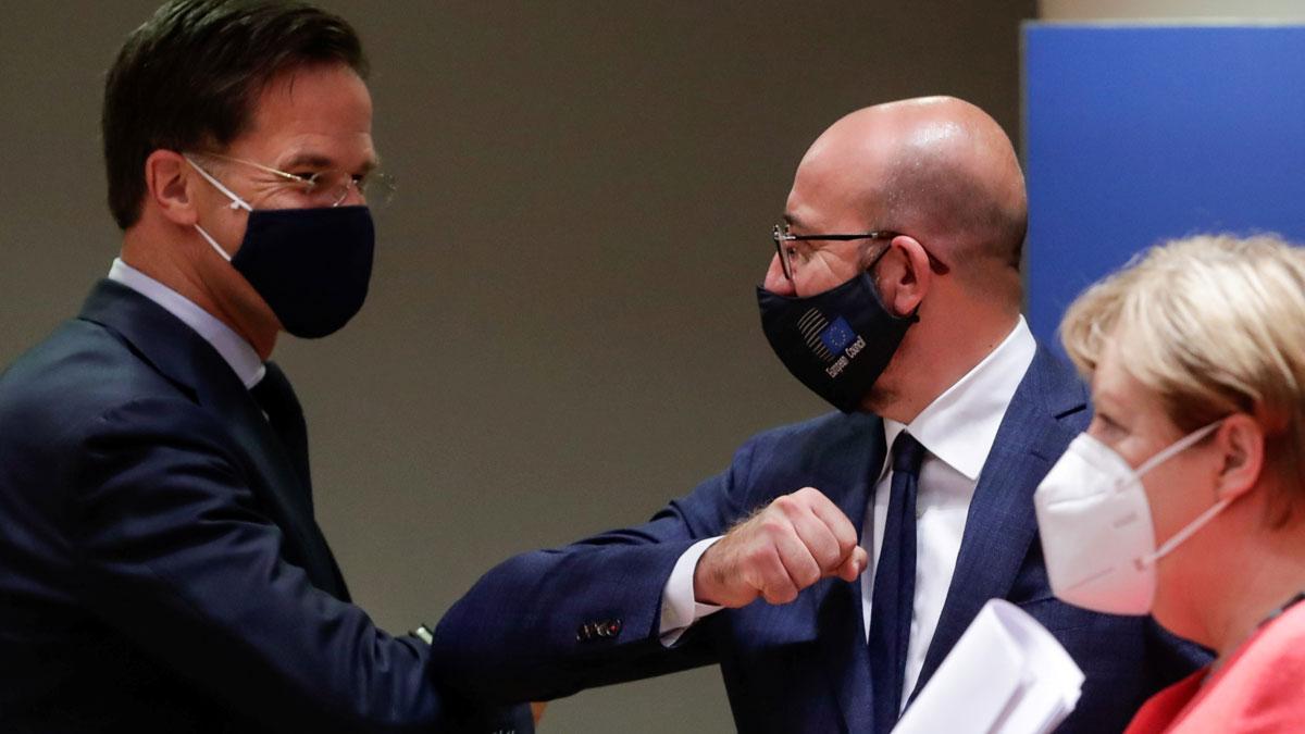 La UE alcanza un acuerdo para salir de la crisis del coronavirus. En la foto, Mark Rutte y Charles Michel se saludan ante Angela Merkel, tras el acuerdo, al final de la cumbre.