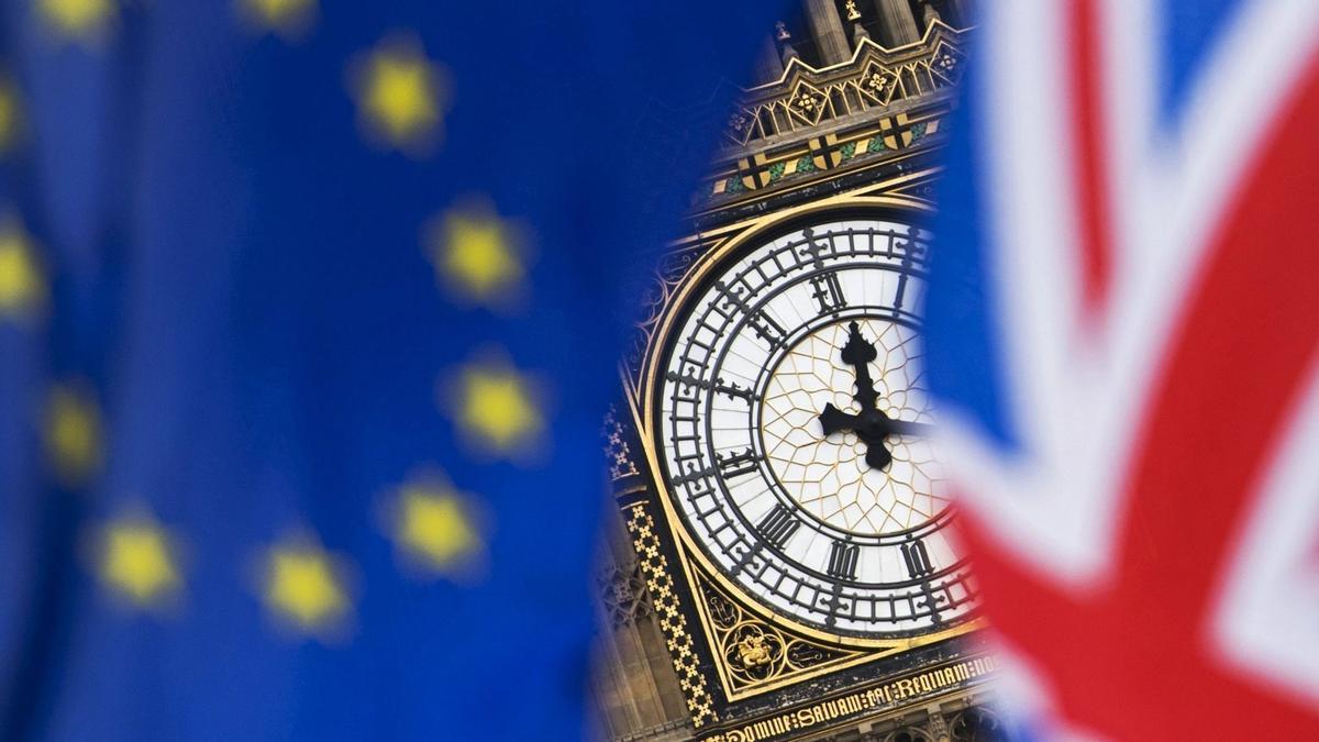 WO023 LONDRES (REINO UNIDO) 05/09/2017.- Vista del reloj del Big Ben entre una bandera del Reino Unido y una de la Unión Europea durante una protesta contra el brexit en el exterior del parlamento británico en Londres (Reino Unido), hoy 5 de septiembre de 2017. El ministro para la salida británica de la UE, David Davis, informa hoy a la Cámara de los Comunes de los progresos de la tercera ronda de negociaciones sobre el brexit. EFE/Will Oliver