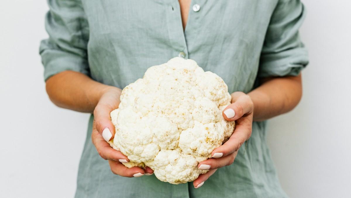 Una mujer sujeta una coliflor. Una mujer sujeta una coliflor.