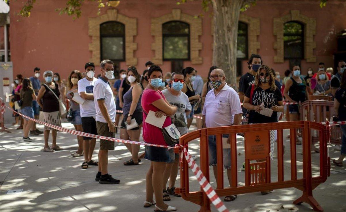 Gente con mascarilla espera para realizarse una prueba PCR en Vilafranca del Penedès.