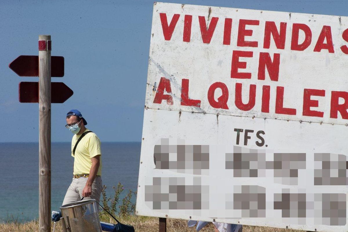 Un hombre camina junto a un cartel de viviendas en alquiler en A Mariña (Lugo/Galicia) Un hombre camina junto a un cartel de viviendas en alquiler en A Mariña (Lugo/Galicia)