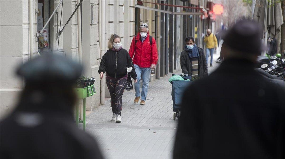 coronavirus. Gente con mascarilla por las calles de Barcelona.