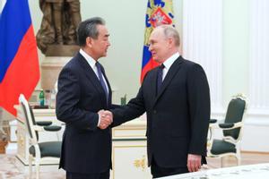 El presidente ruso, Vladímir Putin, estrecha la mano del jefe de la diplomacia china, Wang Yi, este miércoles en el Kremlin.