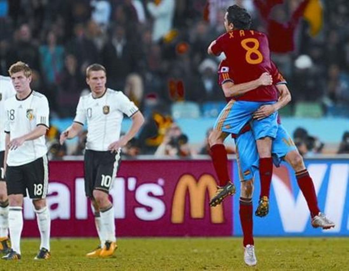 Xabi y Busquets se abrazan tras el gol ante la decepción de los jugadores alemanes. Xabi y Busquets se abrazan tras el gol ante la decepción de los jugadores alemanes.