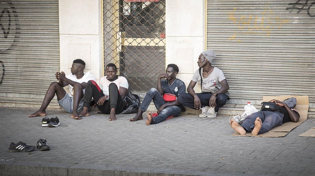Varios temporeros sin trabajo descansan en plena calle, el 3 de julio en Lleida. Varios temporeros sin trabajo descansan en plena calle, el 3 de julio en Lleida.