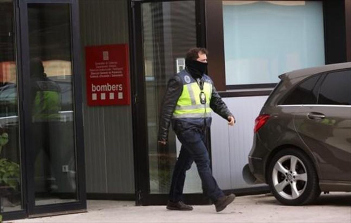 Un policía sale de la sede de los bomberos de Sant Boi, mientras se procedía al registro, ayer. Un policía sale de la sede de los bomberos de Sant Boi, mientras se procedía al registro, ayer.