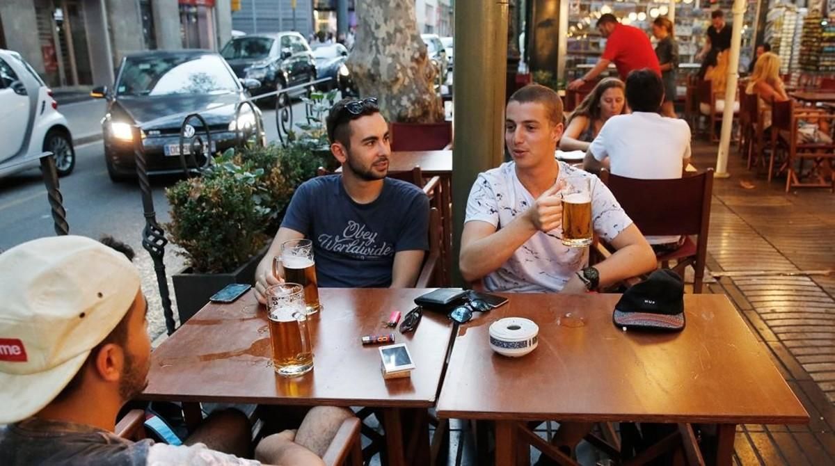 Unos turistas consumiendo jarras de cerveza en el centro de Barcelona. Unos turistas consumiendo jarras de cerveza en el centro de Barcelona.