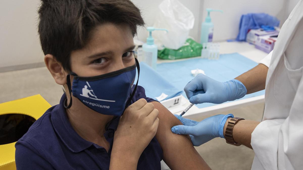 Un joven recibe la primera vacuna, en el punto de vacunación del Palau Firal de Girona.