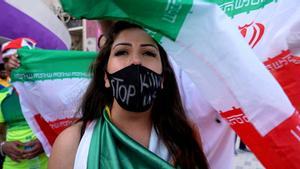Una mujer con una máscara con un mensaje que dice dejad de matarnos tras el partido Gales contra Irán, en Qatar.