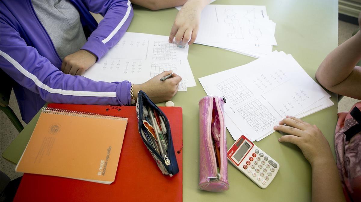 Unos estudiantes hacen deberes en la biblioteca de su colegio. Unos estudiantes hacen deberes en la biblioteca de su colegio.