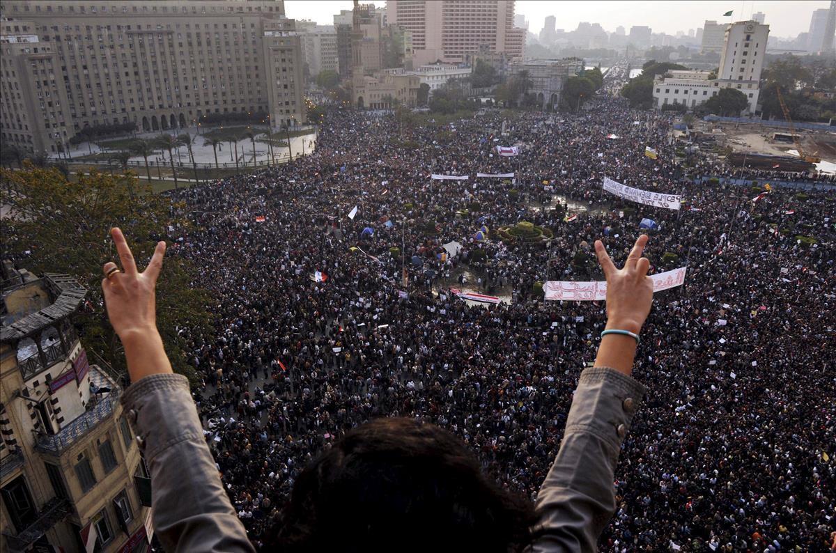 Una mujer hace el signo de la victoria delante de miles de personas que participan en la marcha del millón en la plaza Tahrir de El Cairo, Egipto, el 1 de febrero del 2011.
