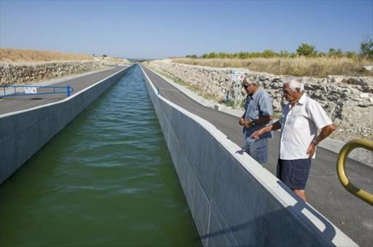 Dos vecinos de la zona contemplan el paso del agua por el Segarra-Garrigues, cerca de Les Borges, ayer. Dos vecinos de la zona contemplan el paso del agua por el Segarra-Garrigues, cerca de Les Borges, ayer.