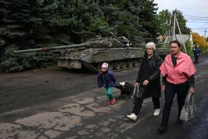 Residentes de Kramatorsk pasan junto a un tanque ruso en el este de Ucrania. 