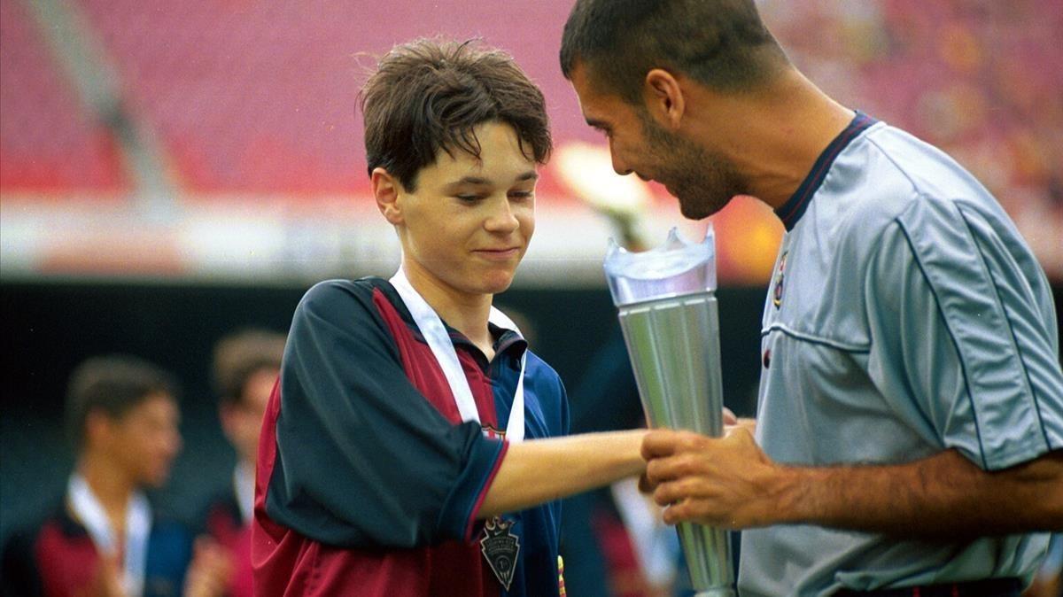Andrés Iniesta recibe el trofeo Nike Cup de manos de Pep Guardiola en 1999.