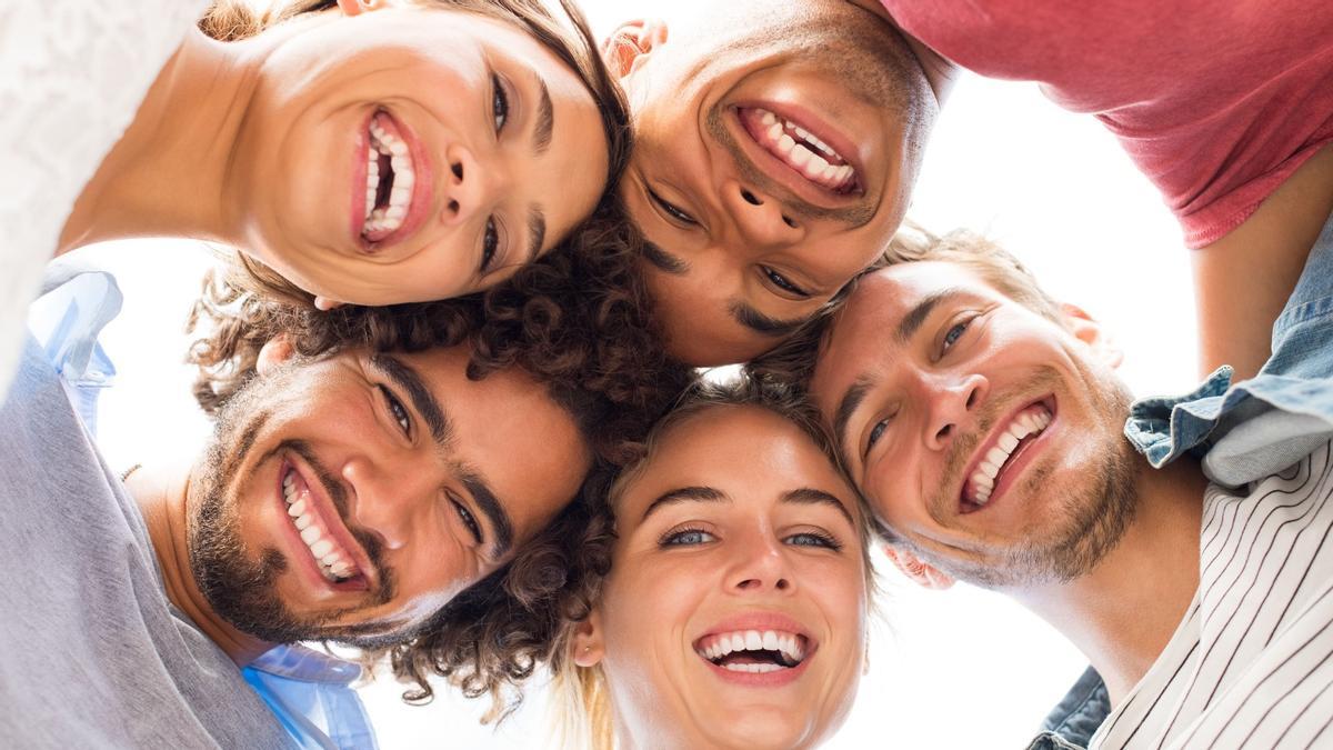 Un grupo de personas sonríen formando un círculo.