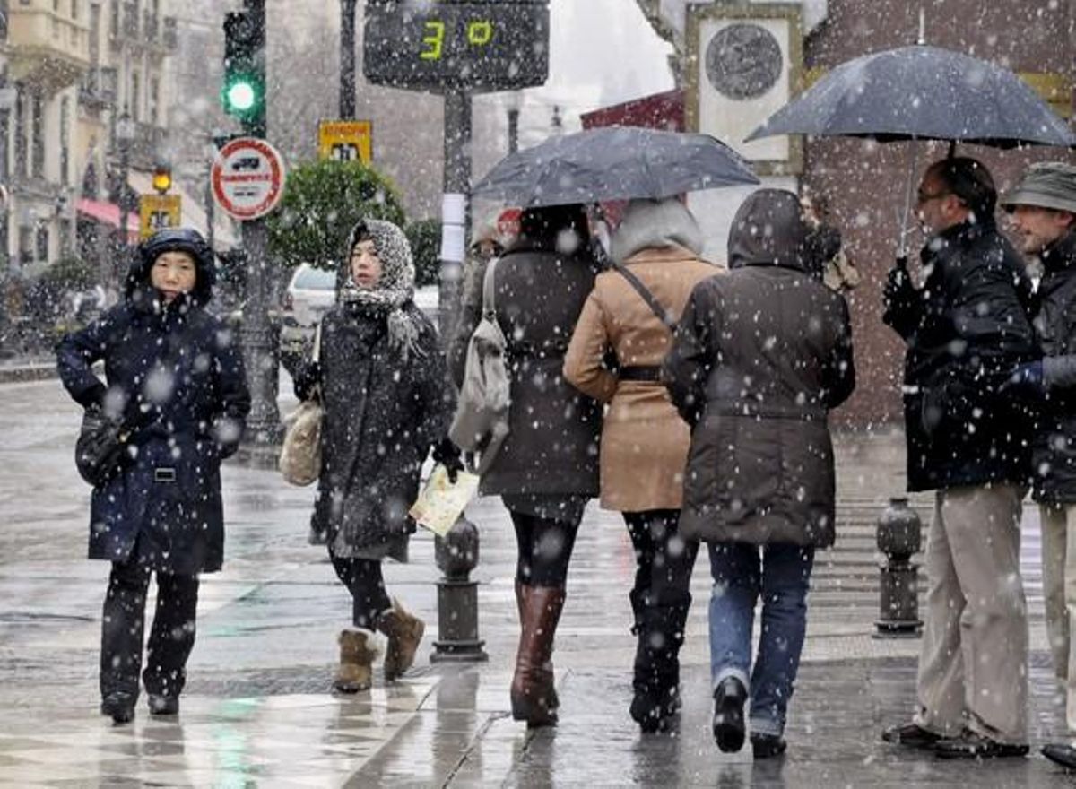 Varias personas pasean por una céntrica calle de Granada durante un temporal de lluvia y frío del pasado invierno. Varias personas pasean por una céntrica calle de Granada durante un temporal de lluvia y frío del pasado invierno.
