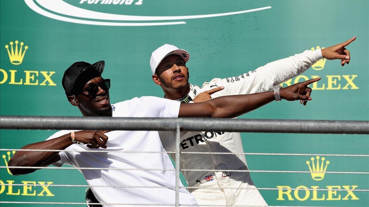 Lewis Hamilton celebra su victoria con Usain Bolt en el podio de Austin.