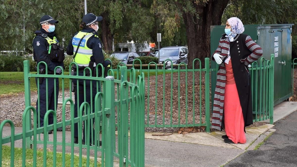 Un policía atiende a una mujer en un puesto de control en Melbourne. Un policía atiende a una mujer en un puesto de control en Melbourne.