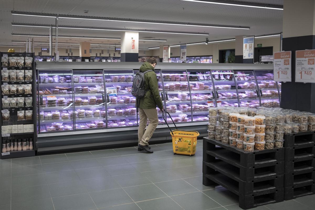 Un cliente en las neveras de carne envasada de un supermercado Bonpreu, en una imagen de archivo.