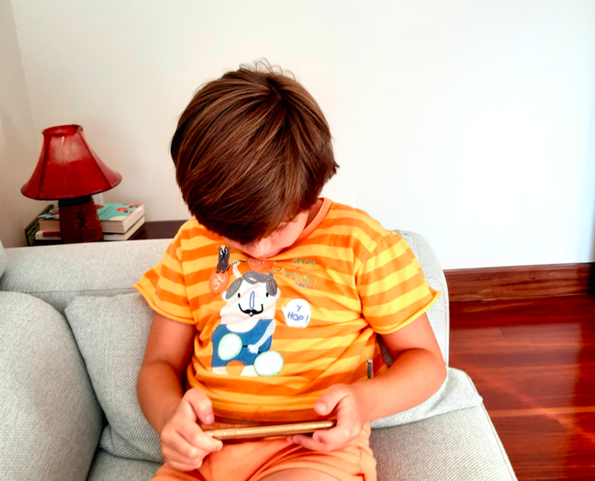 Un niño juega con el móvil de su madre. Un niño juega con el móvil de su madre.