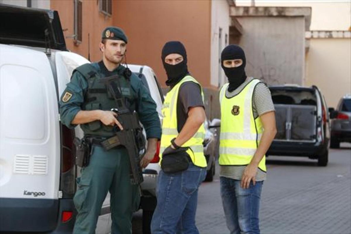 Dos agentes de la Guardia Civil y uno de los Mossos trabajan conjuntamente en una operación antiterrorista.