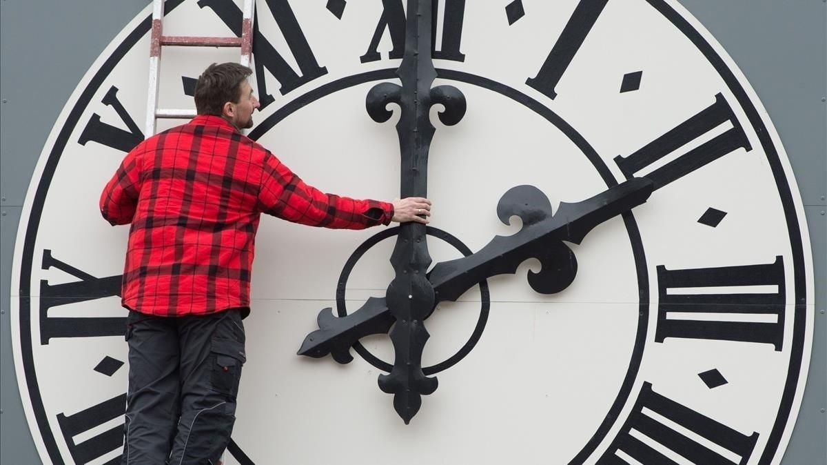Un operario cambia las manecillas del reloj de una iglesia de Dresde, en Alemania. Un operario cambia las manecillas del reloj de una iglesia de Dresde, en Alemania.