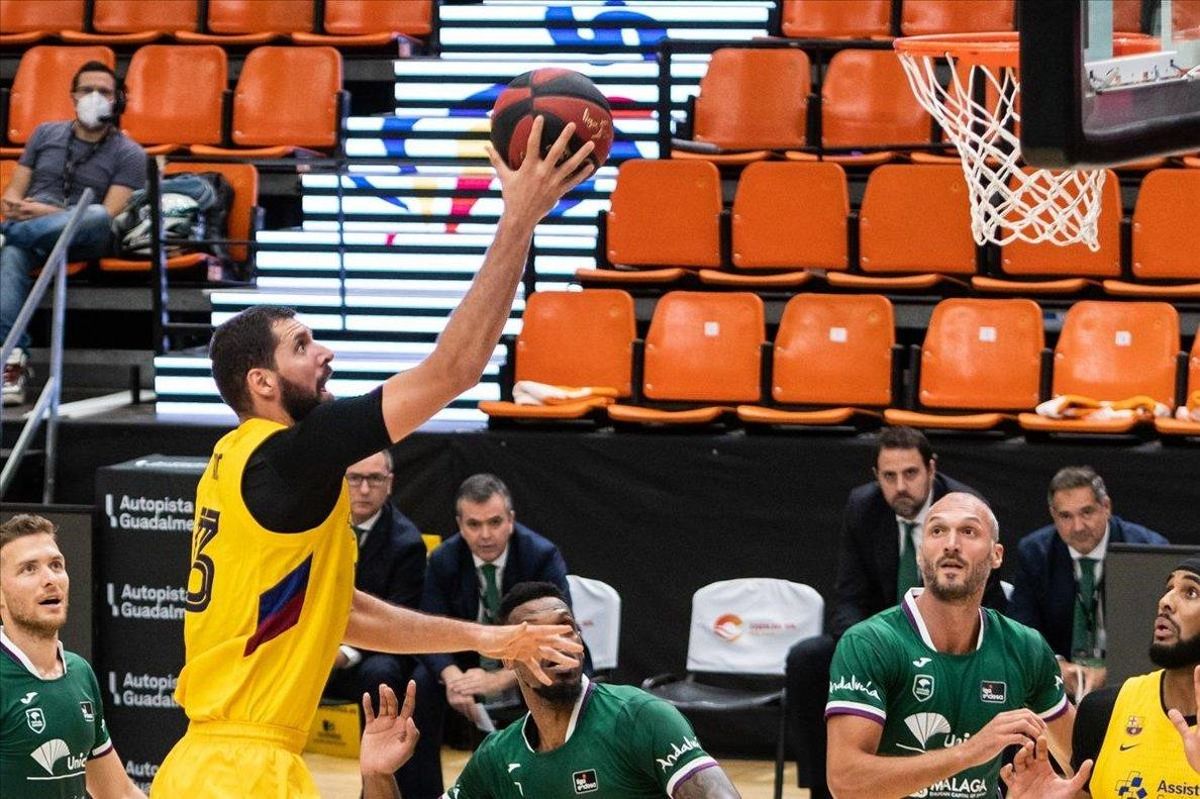 Mirotic deja una bandeja ante la mirada de varios jugadores malagueños Mirotic deja una bandeja ante la mirada de varios jugadores malagueños