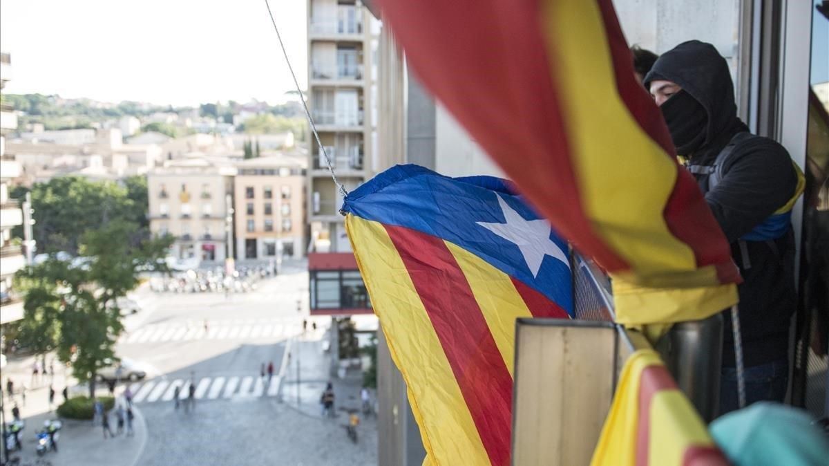 Miembros del CDR descuelgan la bandera española de la Delegacio Del Govern en Girona Miembros del CDR descuelgan la bandera española de la Delegacio Del Govern en Girona