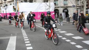Usuarios del Bicing circulan por la plaça Francesc Macià
