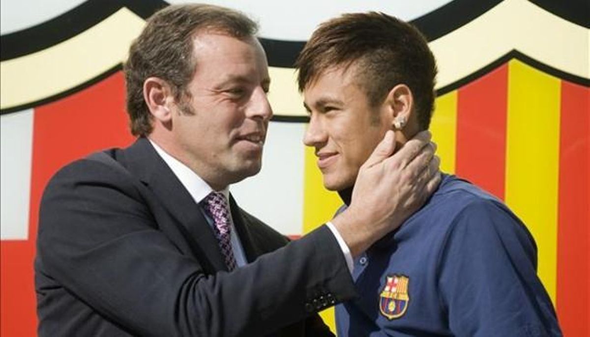 Rosell y Neymar posan ante el escudo del Barça en las oficinas del club el día de la presentación del jugador. Rosell y Neymar posan ante el escudo del Barça en las oficinas del club el día de la presentación del jugador.