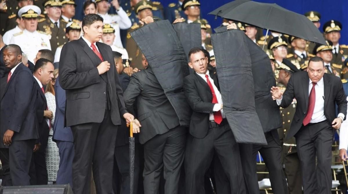 Personal de seguridad protege a Nicolás Maduro tras el atentado con drones en Venezuela. Personal de seguridad protege a Nicolás Maduro tras el atentado con drones en Venezuela.