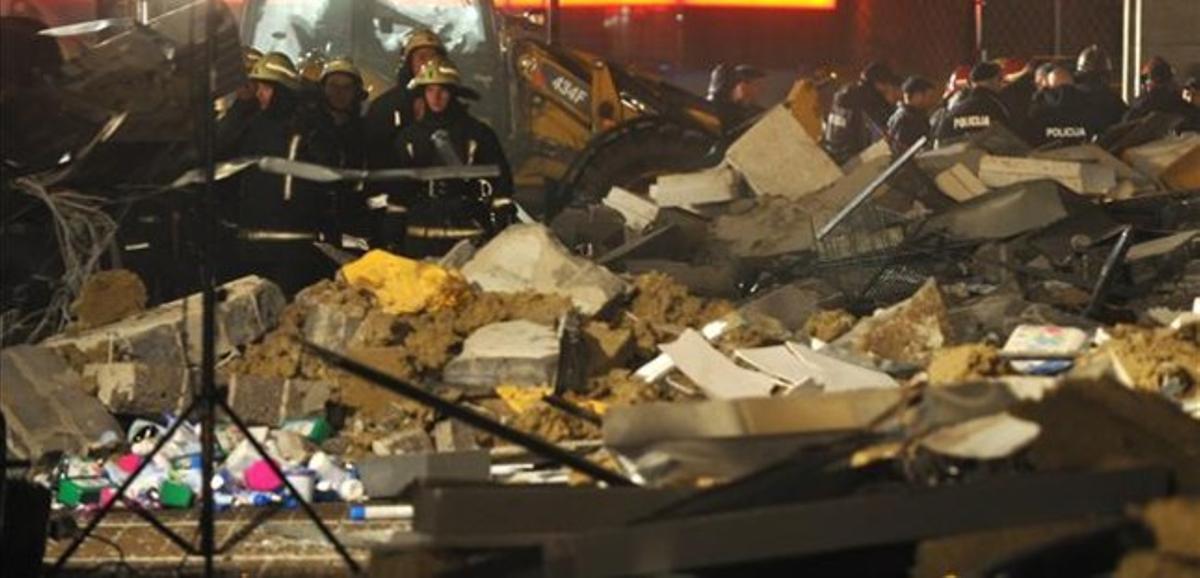 Miembros de los equipos de rescate buscan supervivientes entre los escombros, en Riga,