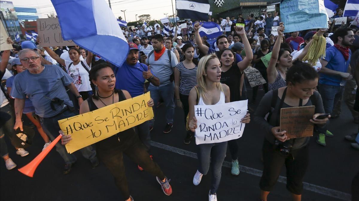 Manifestantes sostienen carteles contra el presidente Ortega, en Managua, el 22 de abril.
