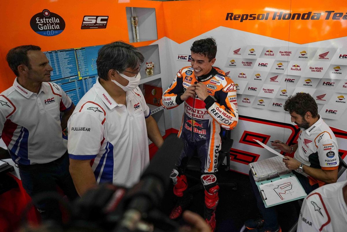 Marc Márquez sonrie, feliz, al llegar a su boxe, ante la mirada de Alberto Puig, a la izquierda, y mientras Santi Hernández, su ingeniero, revisa sus papeles. Marc Márquez sonrie, feliz, al llegar a su boxe, ante la mirada de Alberto Puig, a la izquierda, y mientras Santi Hernández, su ingeniero, revisa sus papeles.