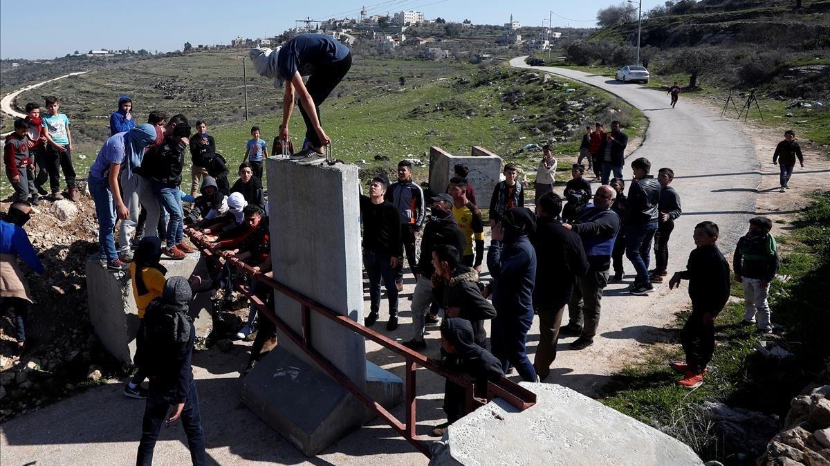 Jóvenes palestinos retiran una barrera de la entrada del pueblo de Aboud, en la Cisjordania ocupada por Israel. Jóvenes palestinos retiran una barrera de la entrada del pueblo de Aboud, en la Cisjordania ocupada por Israel.