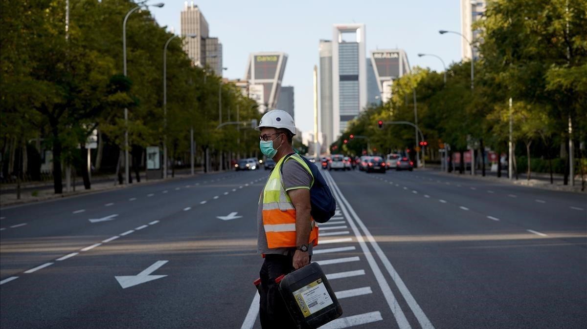 Un trabajador cruza una Castellana inusualmente vacía en Madrid, este miércoles.