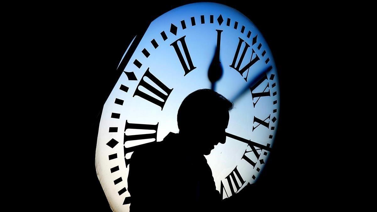 Un hombre paseo con el reloj de la Puerta del Sol al fondo. Un hombre paseo con el reloj de la Puerta del Sol al fondo.