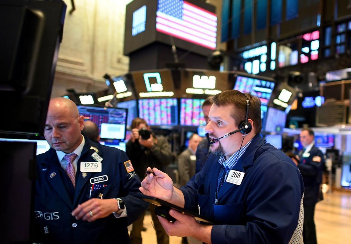 Traders durante el cierre de sesión en el New York Stock Exchange (NYSE) el 18 de marzo de 2020. Traders durante el cierre de sesión en el New York Stock Exchange (NYSE) el 18 de marzo de 2020.