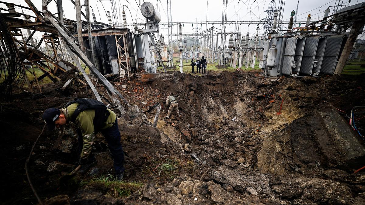 Investigadores inspeccionan el cráter formado por un ataque ruso con misiles en una estación eléctrica en Járkov, en Ucrania.