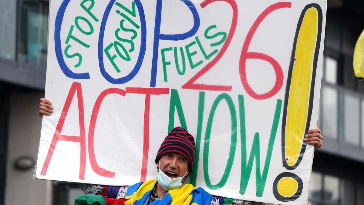 Un activista por el clima protesta con una pancarta durante el último día de la cumbre de Glasgow.