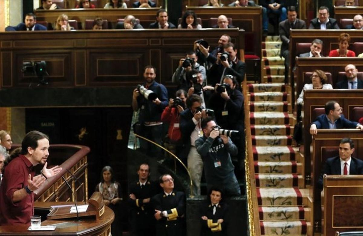 Pablo Iglesias se dirige al hemiciclo en la segunda sesión del debate de investidura con Pedro Sánchez sentado en su escaño.