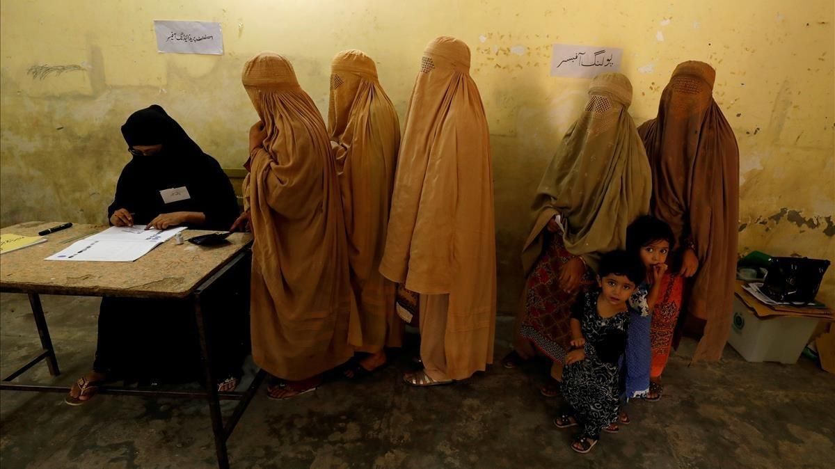 Mujeres ataviadas con burkas votan en un colegio electoral en Peshawar. Mujeres ataviadas con burkas votan en un colegio electoral en Peshawar.