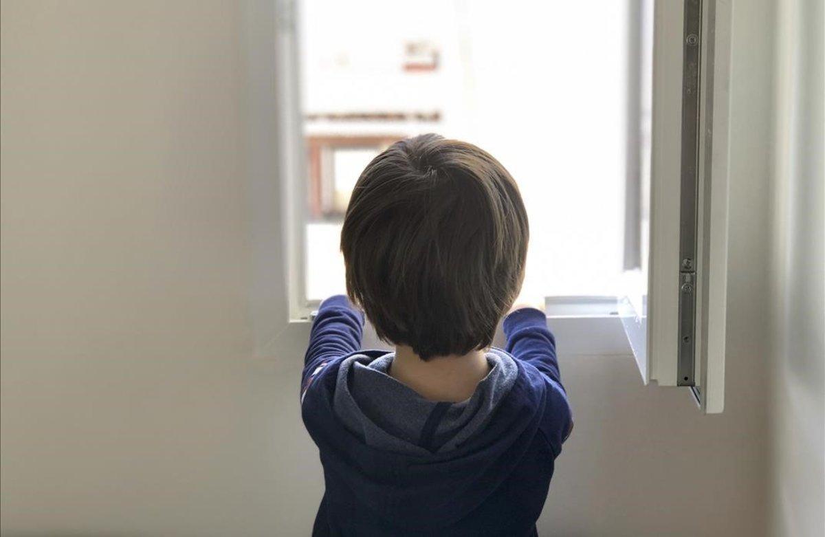 Un niño de cinco años mira por la ventana de su casa en Madrid, de la que no sale desde el pasado 11 de marzo.