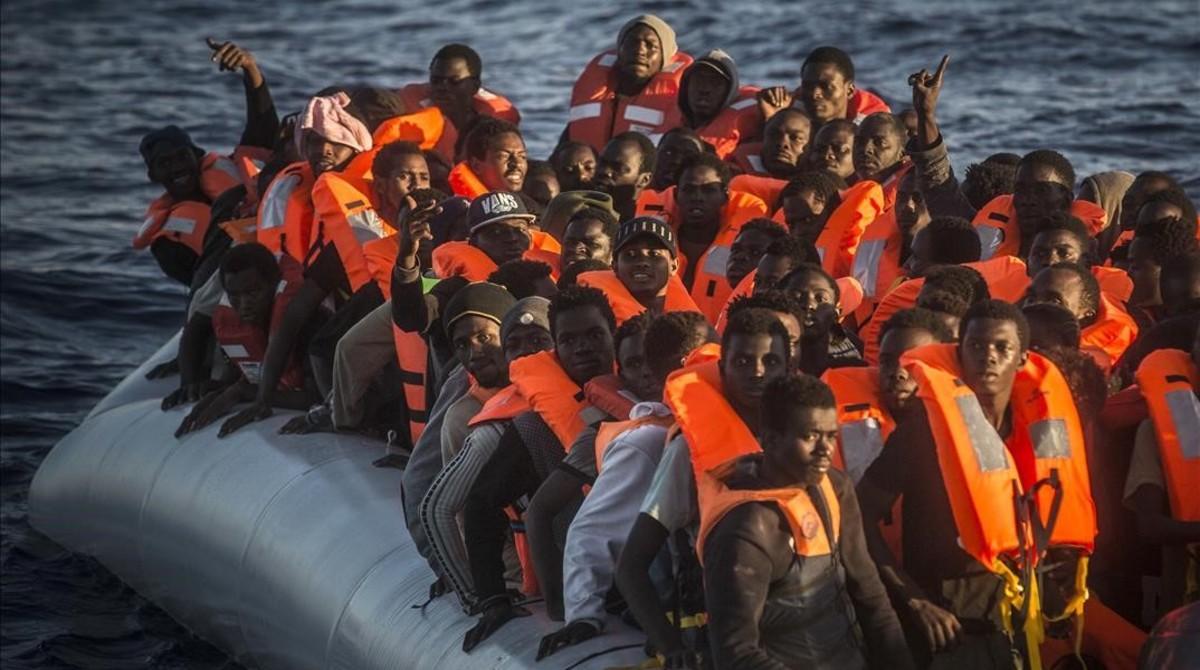 Refugiados e inmigrantes subsaharianos esperan en una barca neumática atiborrada a ser rescatados por el ’Astral’, el 19 de julio, a 24 millas al norte de Sabratha (Libia).