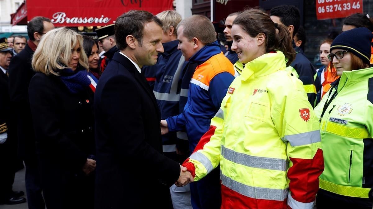 Macron y su mujer, Brigitte (izq), saludan a miembros de los servicios de emergencia delante del bar Comptoir Voltaire, durante una ceremonia por el segundo aniversario de los atentados de París, el 13 de noviembre. Macron y su mujer, Brigitte (izq), saludan a miembros de los servicios de emergencia delante del bar Comptoir Voltaire, durante una ceremonia por el segundo aniversario de los atentados de París, el 13 de noviembre.