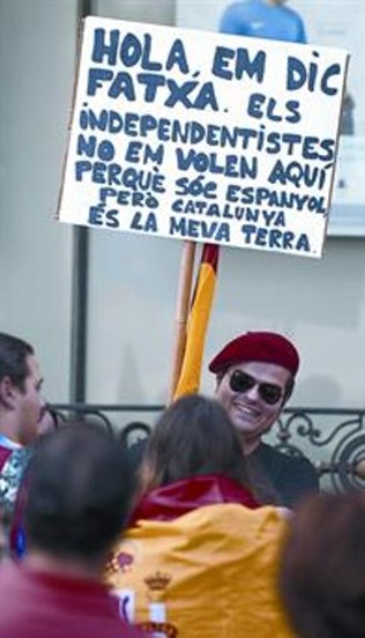 Un asistente al acto de la plaza de Catalunya exhibe un cartel.