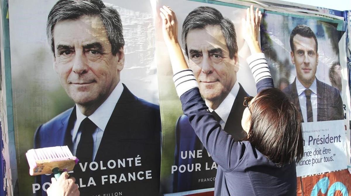 Seguidores de François Fillon pegan carteles de campaña con su imagen en Bayona, el 19 de abril.