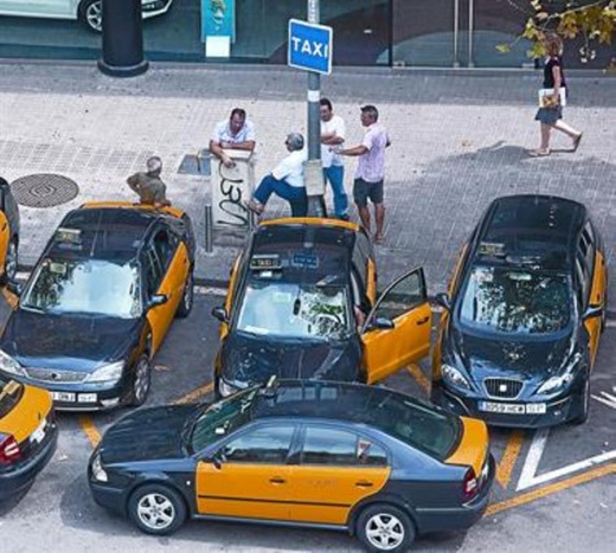 Varios taxistas aguardan la llegada de clientes en la parada de Diputació con Rambla de Catalunya, foto de archivo. Varios taxistas aguardan la llegada de clientes en la parada de Diputació con Rambla de Catalunya, foto de archivo.
