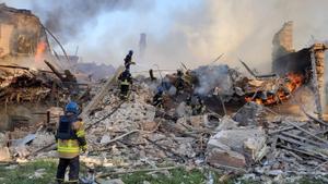 Equipos de emergencia en los escombros en llamas de una escuela alcanzada por un bombardeo, en el pueblo de Bilohorivka , Lugansk.