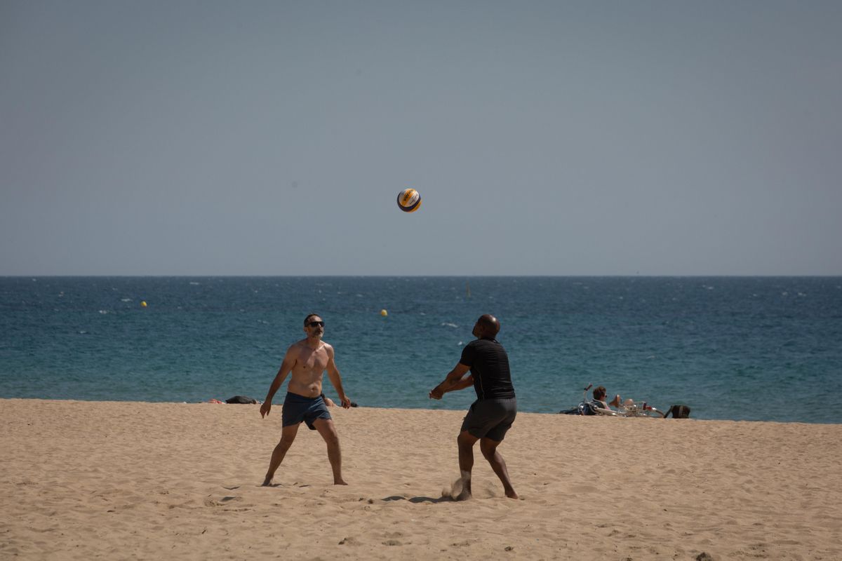 Dos hombres juegan al voleibol en la playa del Bogotell el día de la presentación del protocolo para el control del aforo de playas. Dos hombres juegan al voleibol en la playa del Bogotell el día de la presentación del protocolo para el control del aforo de playas.